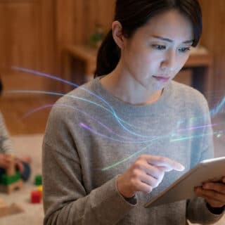 Une femme utilise une tablette avec des données numériques holographiques, un enfant joue en arrière-plan.