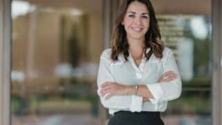 Femme professionnelle souriante, bras croisés, dans un bureau